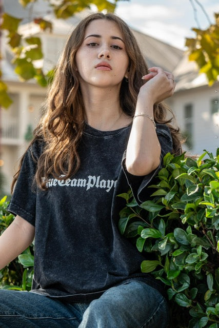 Model wearing the black washed lightweight t-shirt, seated outdoors