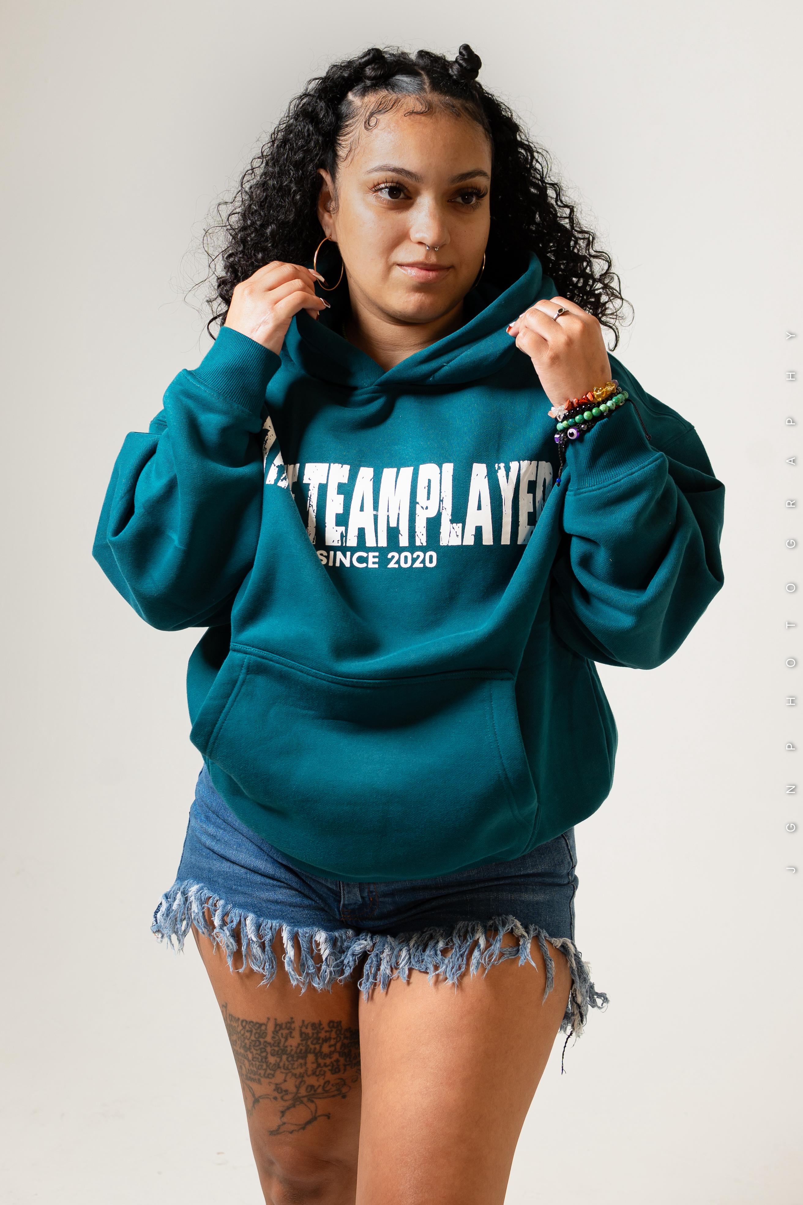 Model wearing the teal blue True Team Players oversized pullover hoodie